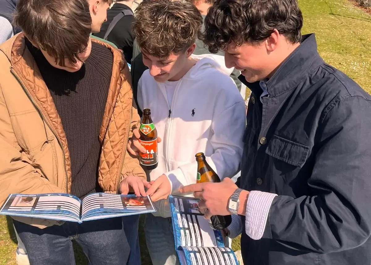 Junge Erwachsene blättern gemeinsam in einem Flashbook